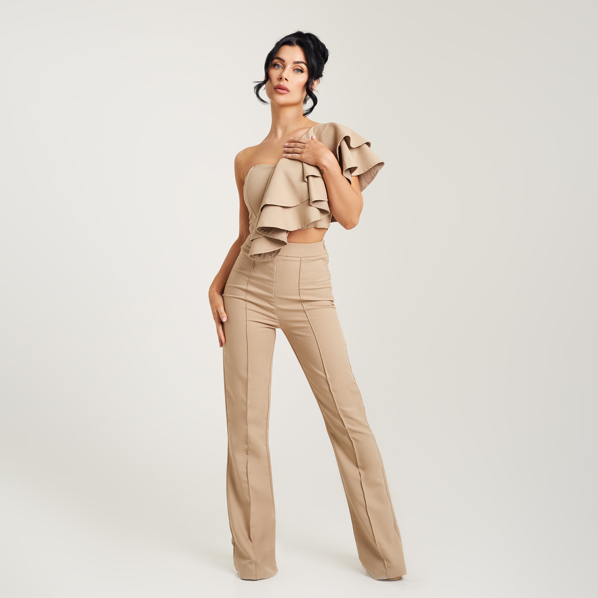  pair of women's high-waisted, wide-leg suit trousers in a soft beige color. The trousers feature a tailored fit and sit comfortably at the waist, accentuating the feminine silhouette. The wide legs gracefully flow down, creating a sophisticated and elegant look. The neutral beige tone adds a timeless touch to the ensemble, making these trousers versatile for various occasions. Whether paired with a blouse for a professional setting or dressed down with a casual top, these trousers offer style and comfort